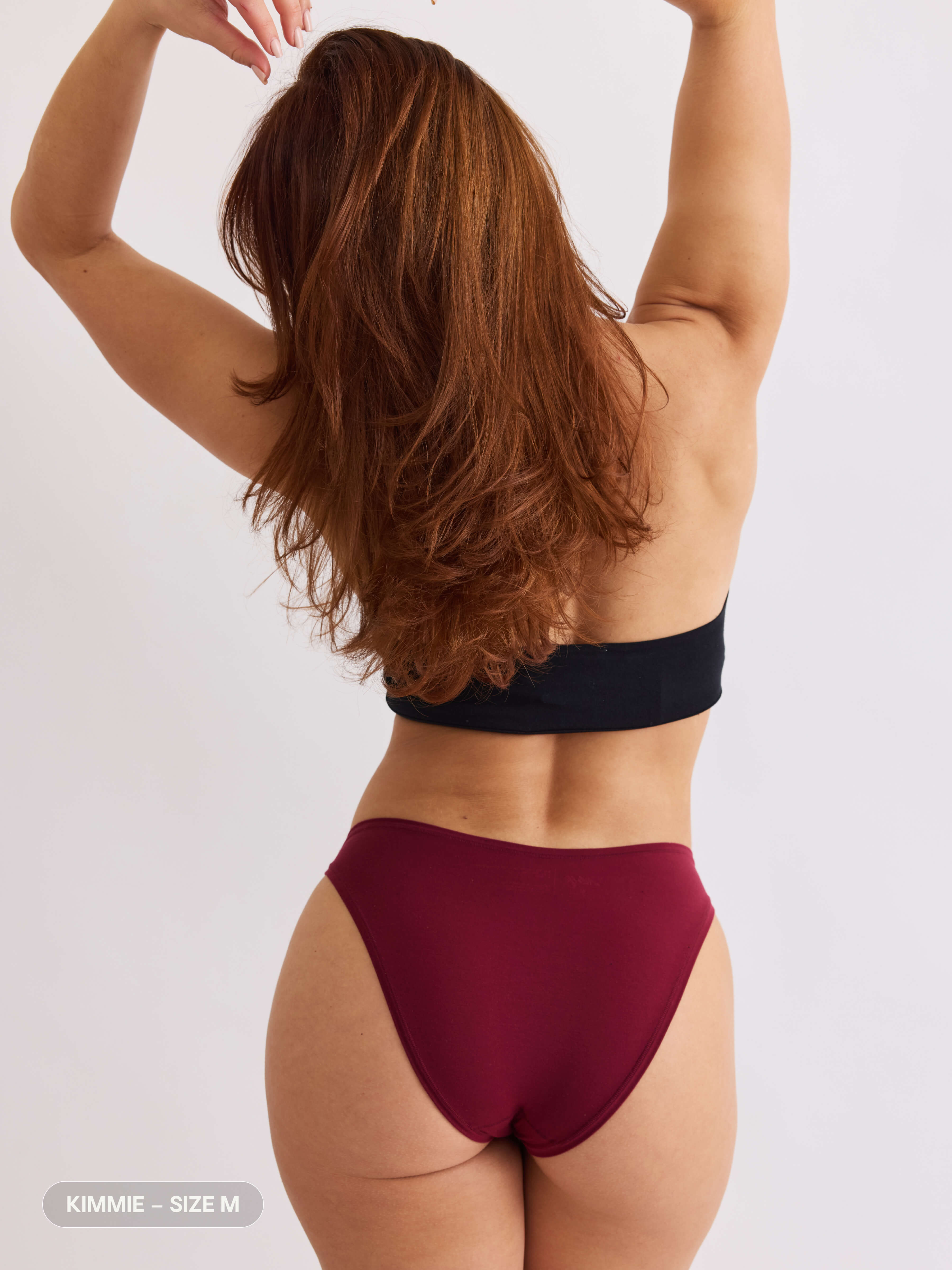 model C wearing merlot red pair of sustainable non-toxic women's underwear back view