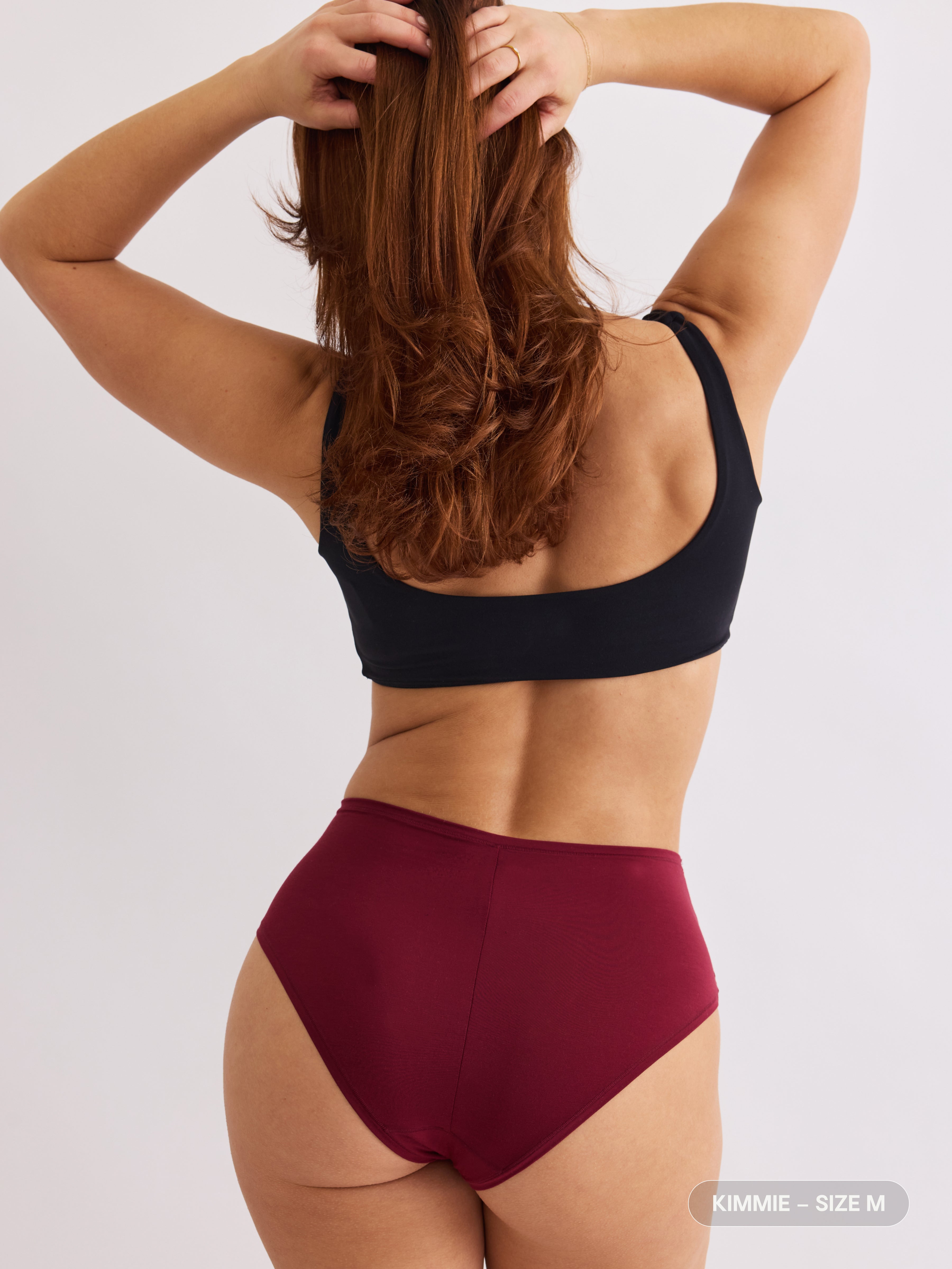 model A wearing red pair of sustainable non-toxic women's underwear back view
