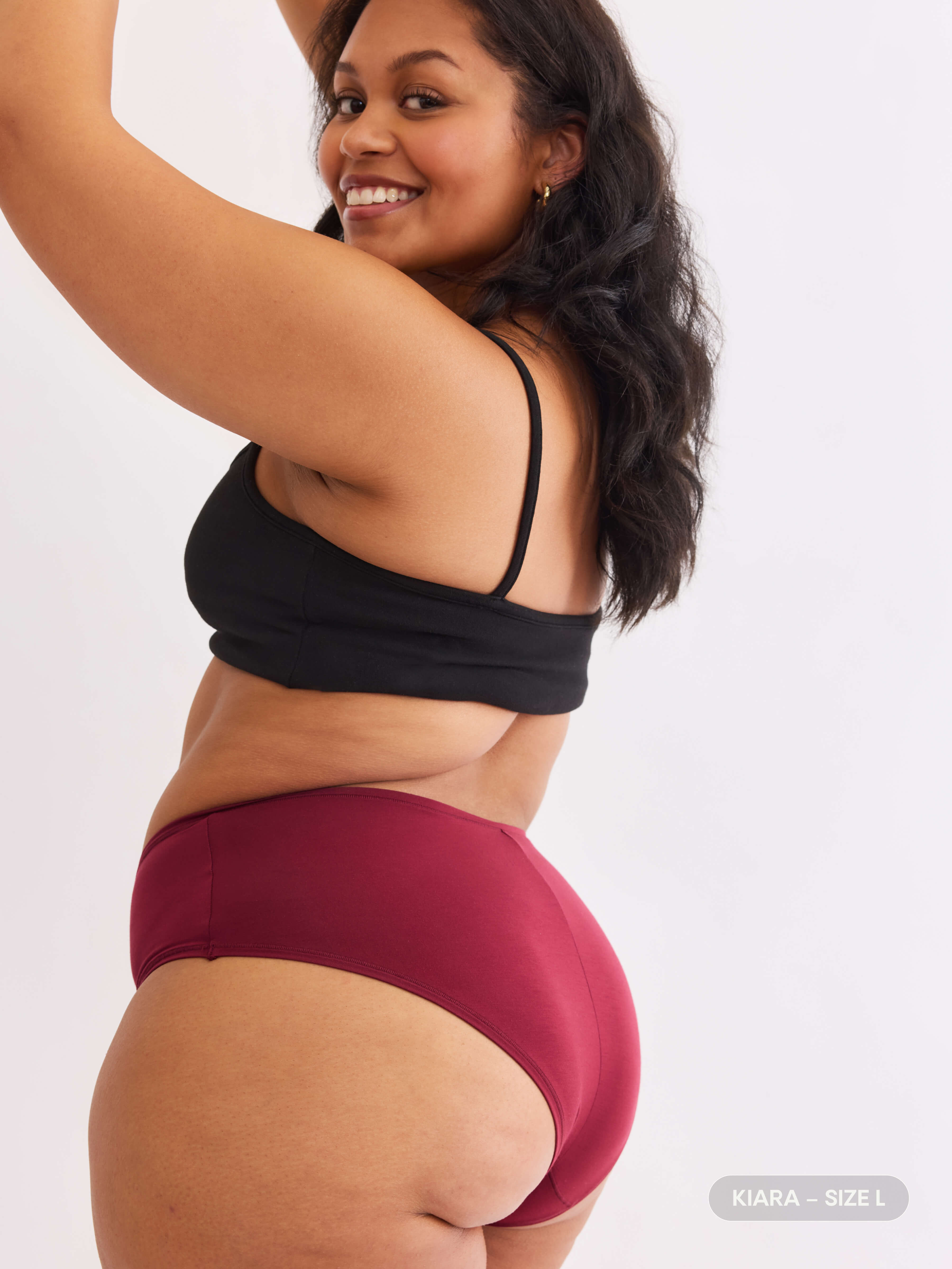 model B wearing red pair of sustainable non-toxic women's underwear back view