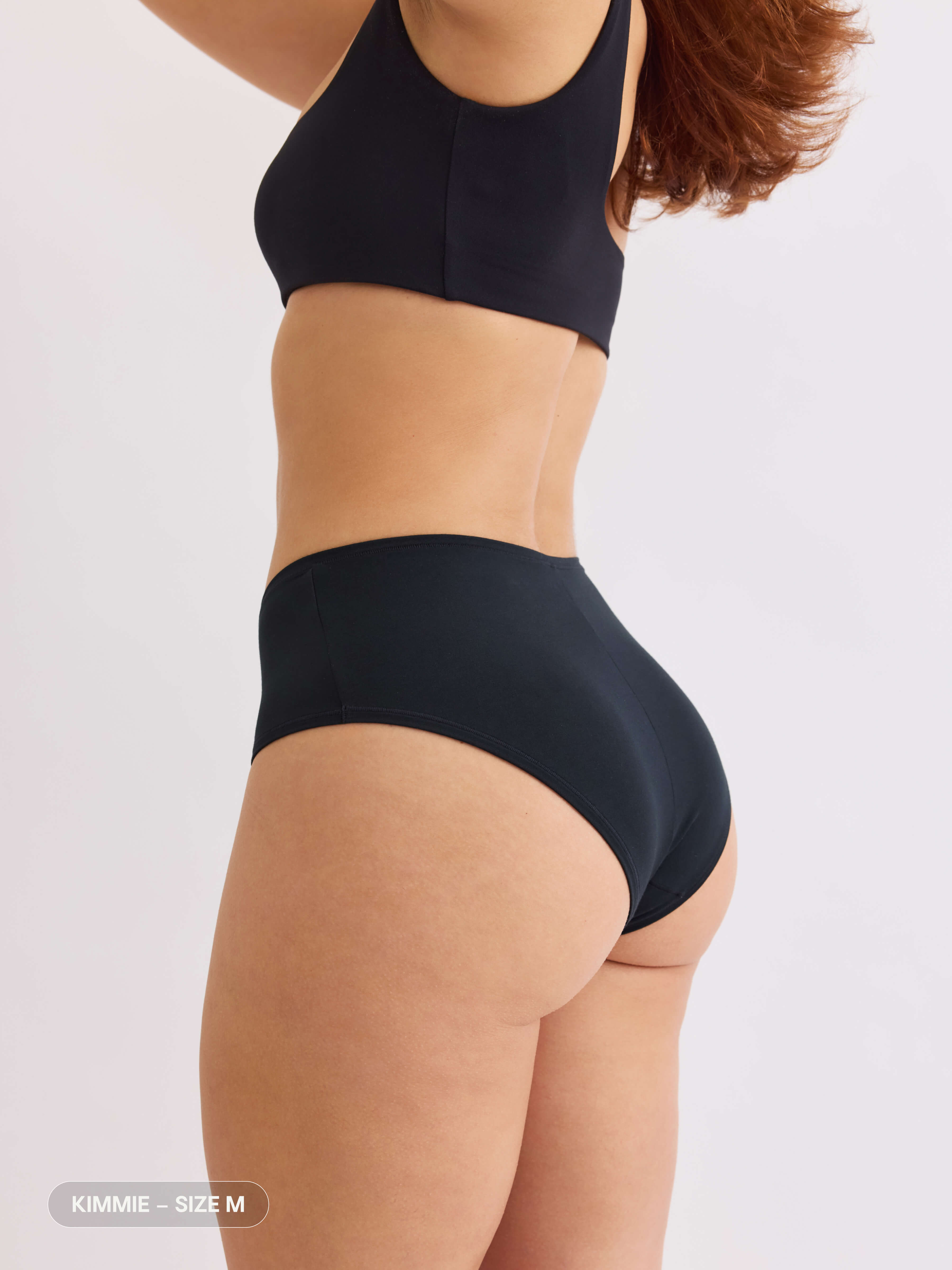model B wearing black pair of sustainable non-toxic women's underwear back view #color_vesper