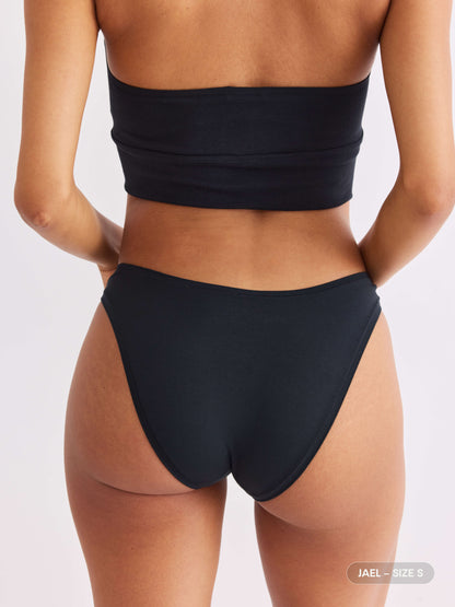 model A wearing vesper black pair of sustainable non-toxic women's underwear  back view 
