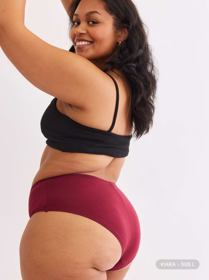 model B wearing red pair of sustainable non-toxic women's underwear back view 