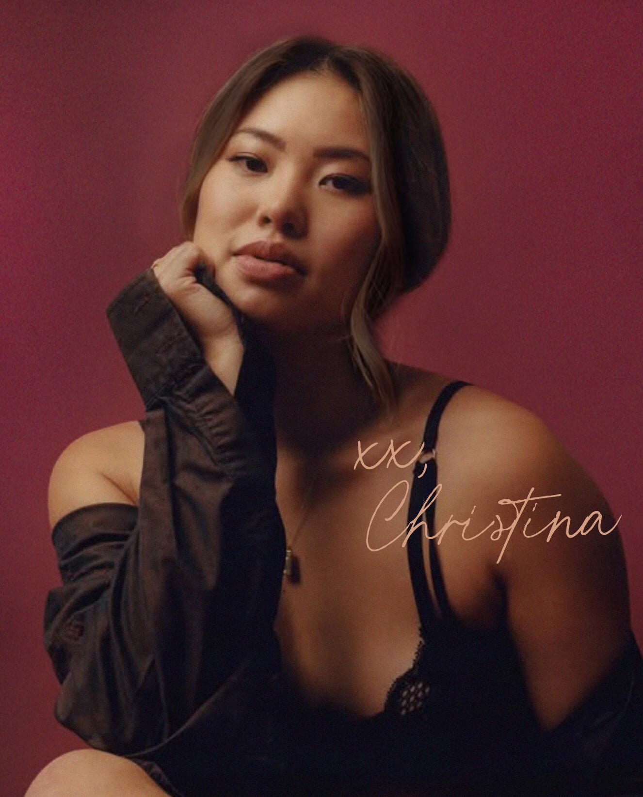 Adelfi founder  wearing a dark top against a pink background with 'xx, Christina' text.